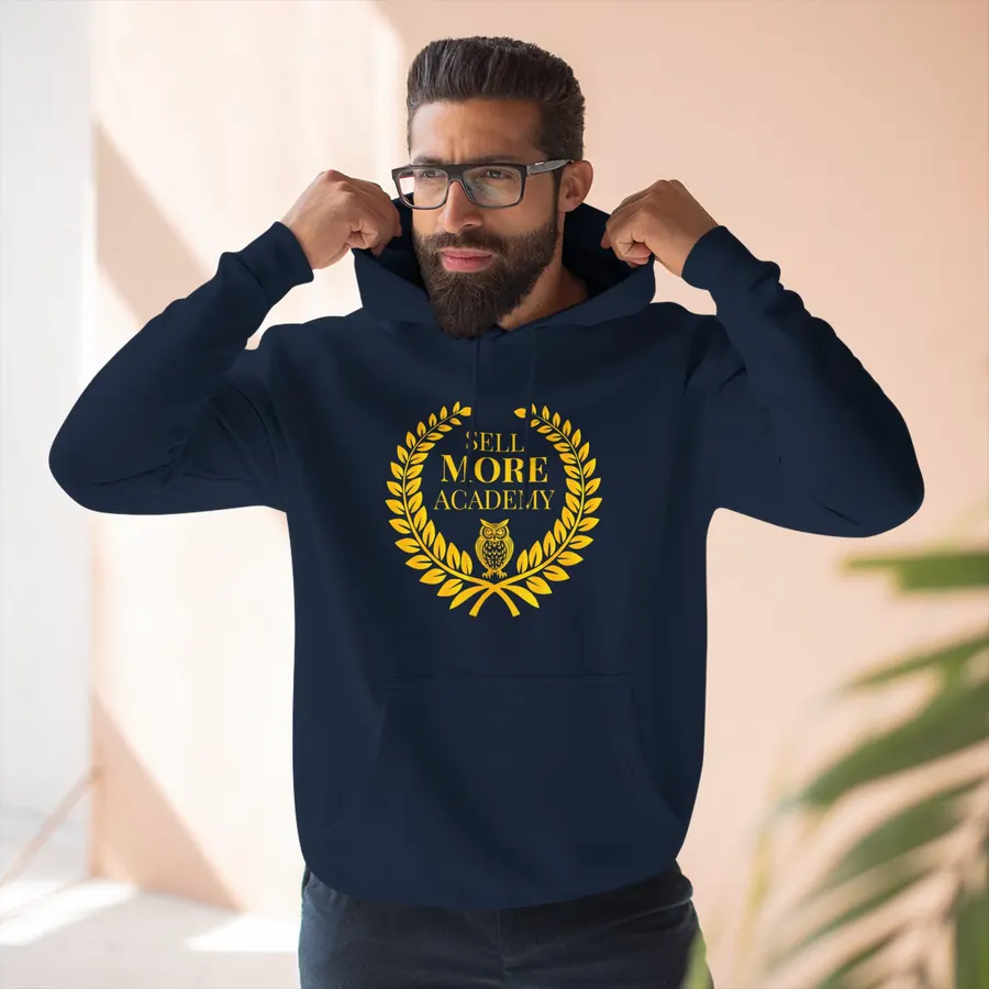 Business owner wearing a navy Sell More Academy hoodie with the gold laurel and owl crest